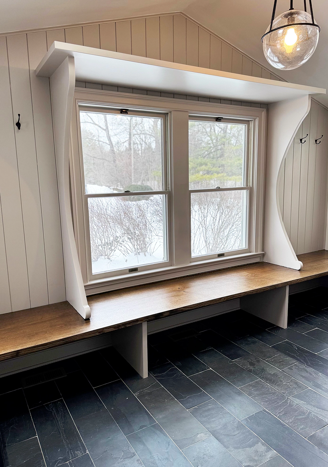 Custom built-in window seat framed with oversized decorative corbels